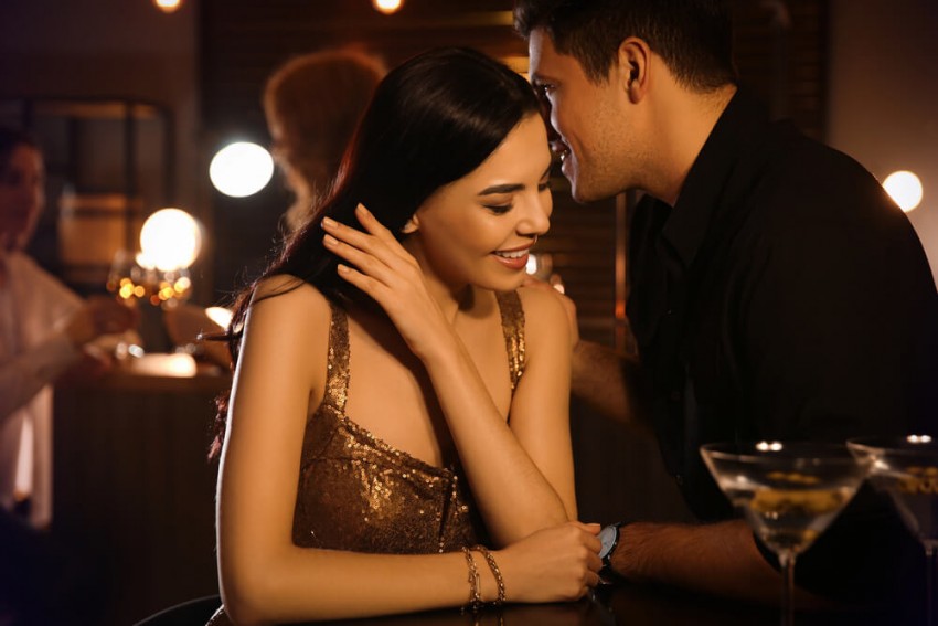 Et attraktivt par oplever stærk kemi og gnister i en bar, et perfekt eksempel på en vellykket seriøs date fyldt med flirt og lidenskab.