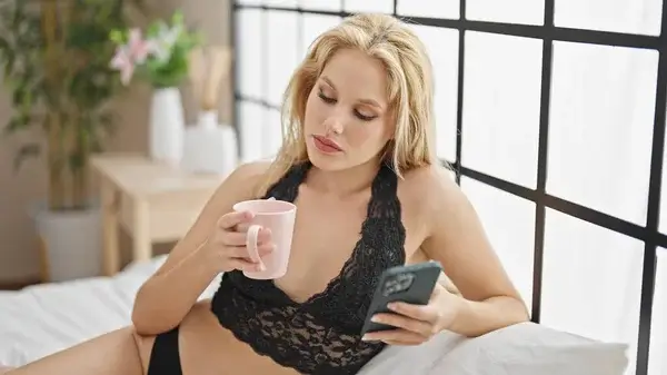 Afslappet kvinde i blondeundertøj sender sexede beskeder i gratis sexchat via mobiltelefon - fjernsexdate.